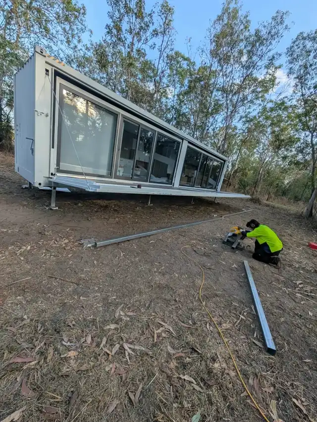 Slide-out container home opened out on its stumps during installation