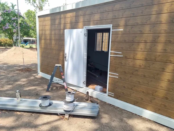 A timber-look container office being fitted out on a bush block